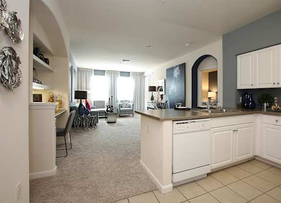 A kitchen with white appliances and cabinets at The Kitt at Warner Center Apartments, Woodland Hills