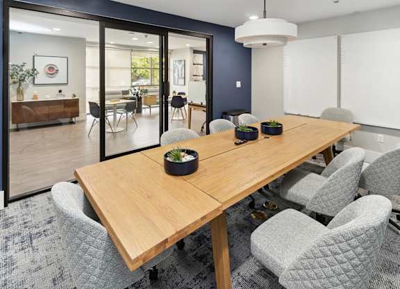 A conference room with a long table and grey chairs at The Kitt at Warner Center Apartments, Woodland Hills 91303
