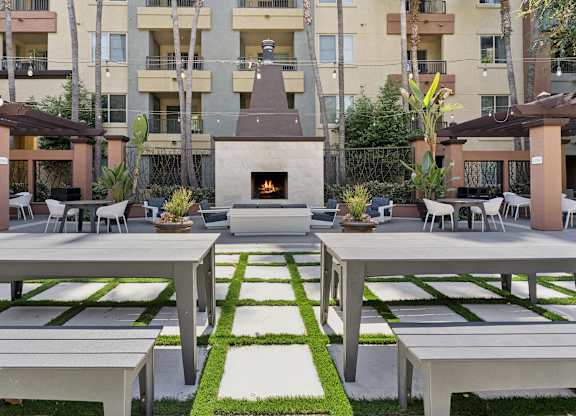 A patio with a fireplace and seating area. at The Kitt at Warner Center Apartments, Woodland Hills