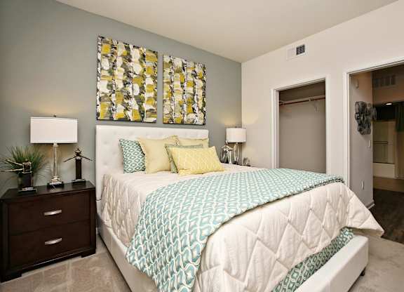 A bedroom with a bed, nightstand, and lamp at The Kitt at Warner Center Apartments, California, 91303