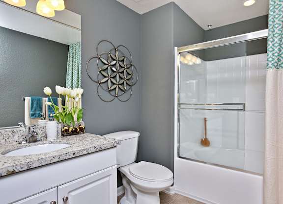 A bathroom with a toilet, sink, and shower at The Kitt at Warner Center Apartments, California, 91303