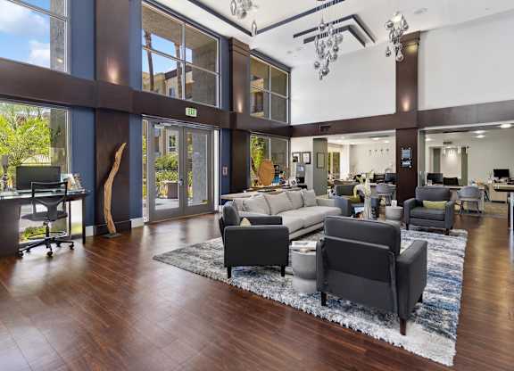 A modern living room with a large rug and a long couch at The Kitt at Warner Center Apartments, Woodland Hills, CA, 91303