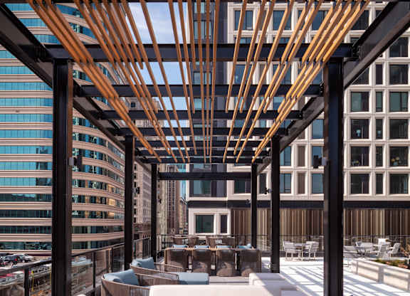 A wooden pergola over a patio with white and blue couches at 365 Nicollet, Manchester