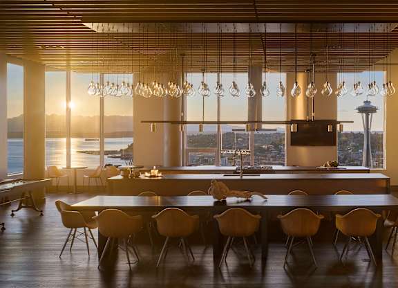 A modern dining room with a large table and chairs.