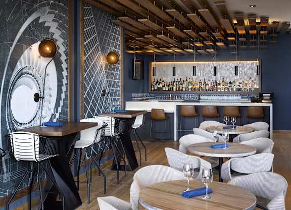 A restaurant with a bar and chairs.