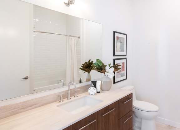 A bathroom with a white sink and a white toilet.