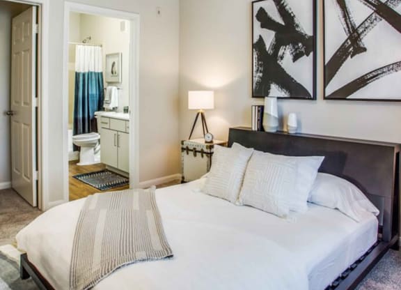 a bedroom with a large bed and a bathroom at Carrington at Barker Cypress, Texas