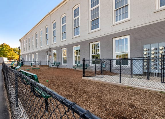a building with a fenced in yard and a chain link fence at Highland Mill Lofts, Charlotte, NC