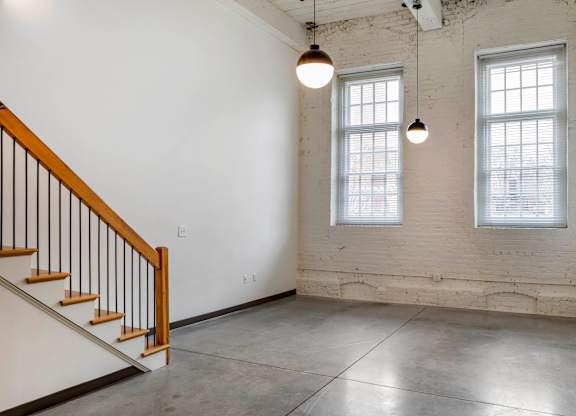 an empty room with two windows and a staircase at Highland Mill Lofts, Charlotte, North Carolina