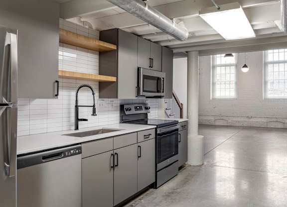 a kitchen with white counter tops and stainless steel appliances at Highland Mill Lofts, Charlotte, 28205