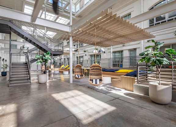 the lobby of an office building with stairs and plants at Highland Mill Lofts, Charlotte, NC