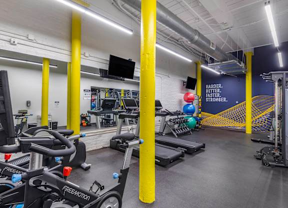 a gym with cardio equipment and weights in a building at Highland Mill Lofts, Charlotte
