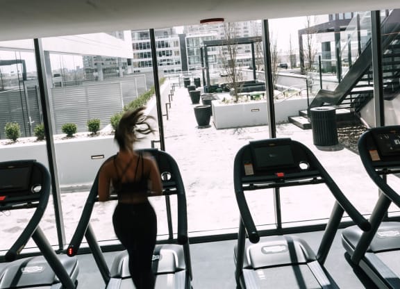 a woman running on a treadmill at the gym at The Grand Central, Chicago, 60607