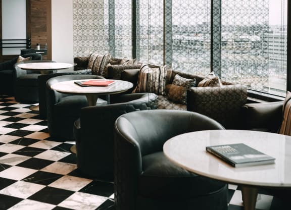 a bar with black chairs and tables and a checkered floor at The Grand Central, Chicago Illinois