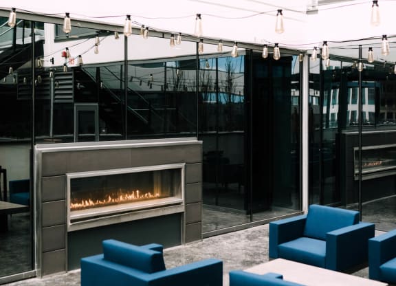 a modern living room with blue couches and a fireplace at The Grand Central, Chicago