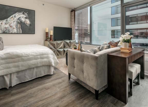 a living room with a bed and a couch and a tv at The Grand Central, Chicago, IL 60607