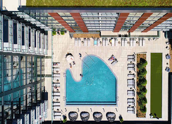 A swimming pool surrounded by lounge chairs and umbrellas. at The Mason Apartments, Illinois, 60607
