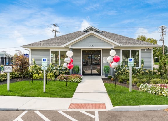 A small building with a grey roof and a sign that says 