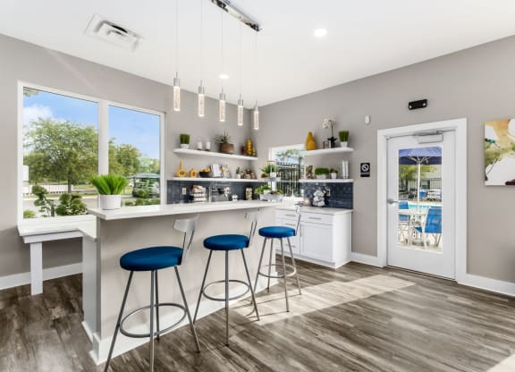 A modern kitchen with blue stools and a white countertop. at Estates at Brentwood Lake Apartments, Reynoldsburg, Ohio