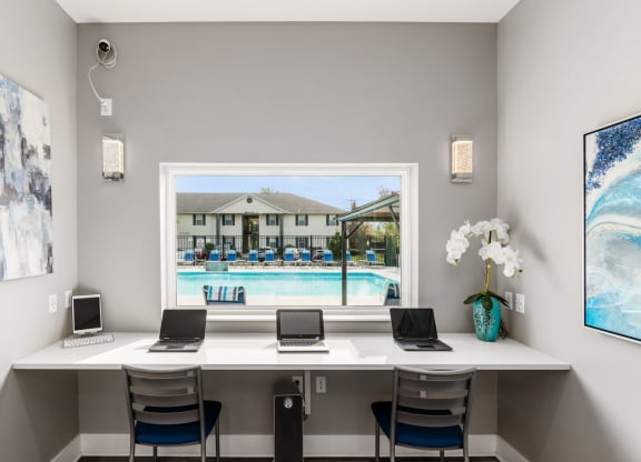 A room with a desk and laptops with a pool in the background at Estates at Brentwood Lake Apartments, Reynoldsburg