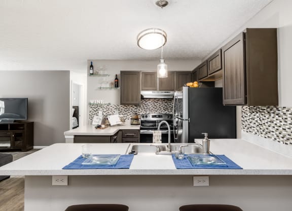 A kitchen with a white countertop and a black refrigerator at Estates at Brentwood Lake Apartments, Reynoldsburg, Ohio