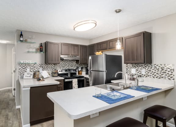 A kitchen with a white counter top and brown cabinets at Estates at Brentwood Lake Apartments, Reynoldsburg, 43068