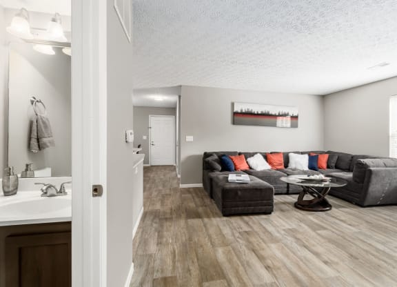 A living room with a grey couch and a wooden floor at Estates at Brentwood Lake Apartments, Reynoldsburg, Ohio