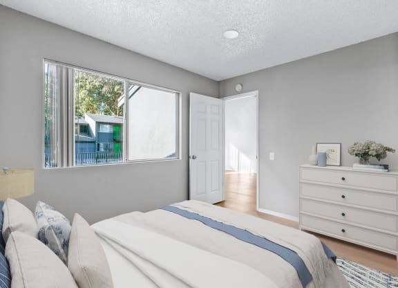 a bedroom with a bed and a dresser and a window