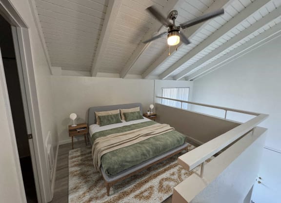 a bedroom with a bed and a ceiling fan