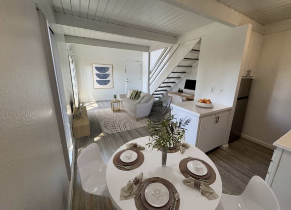 a living room and dining room with a table and chairs