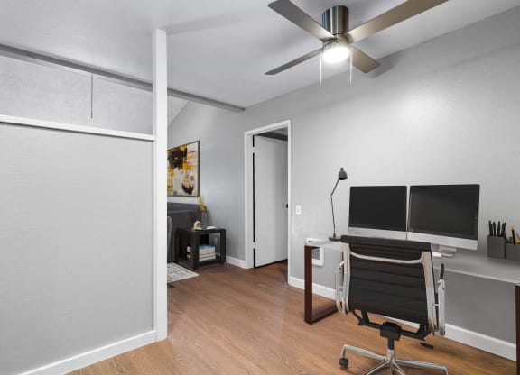 a living room with a desk and a tv