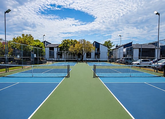 A tennis court with a blue and green surface and a white line down the middle.