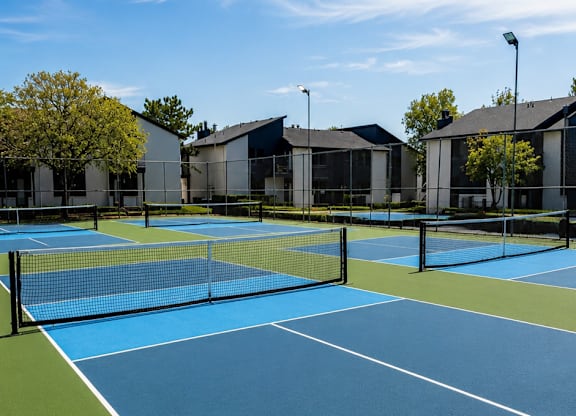 A tennis court with a blue surface and white lines.