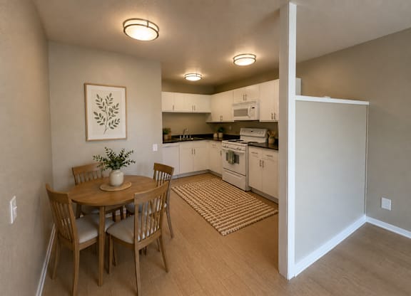 A kitchen with a table and chairs in the foreground and a refrigerator in the background.