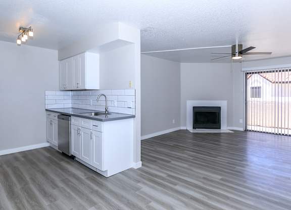 an empty living room with a kitchen and a fireplace at Tides at Mesa, Mesa, AZ, 85204