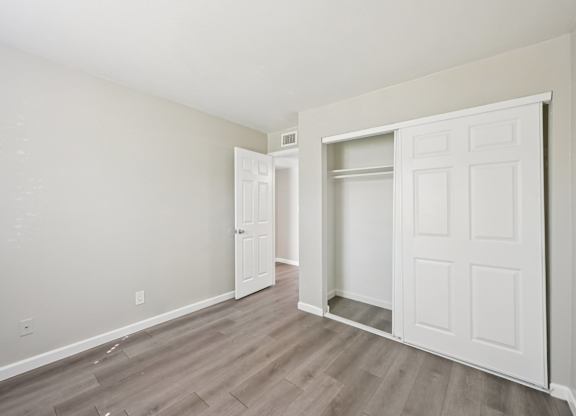 A room with a white door and a white closet.