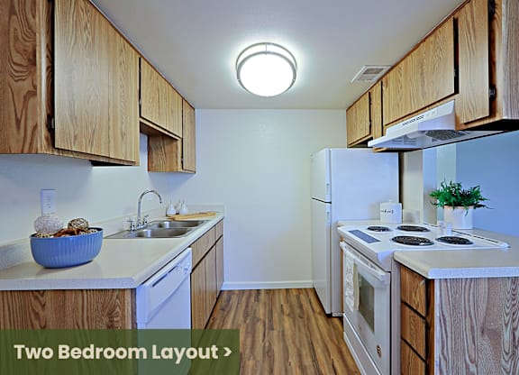 a kitchen with white appliances and wooden cabinets