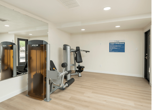 A gym with a row of treadmills and a sign on the wall.
