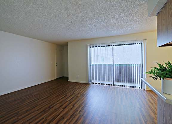 a living room with hardwood floors and a large window