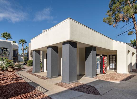 A modern building with a flat roof and a series of pillars in front.