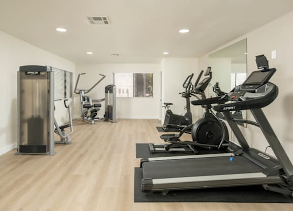 A spacious gym with treadmills, elliptical machines, and a stair climber.