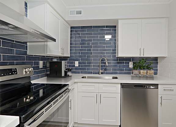 A kitchen with white cabinets and a black stove top oven.