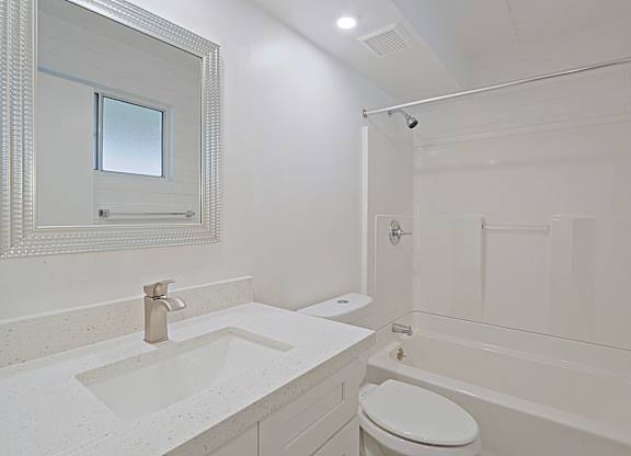 A white bathroom with a sink, toilet, and bathtub.