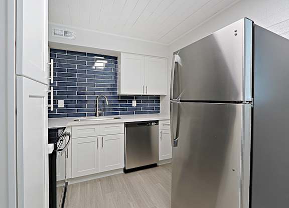 A modern kitchen with a stainless steel refrigerator.