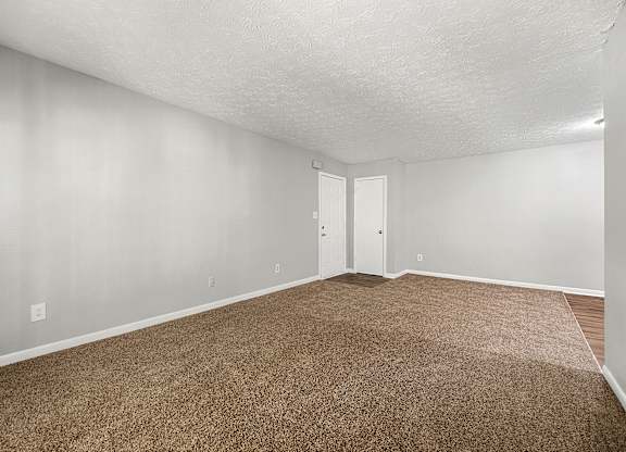A room with brown carpet and white walls.