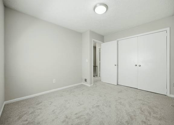 A room with a carpeted floor and a white ceiling with a light fixture.