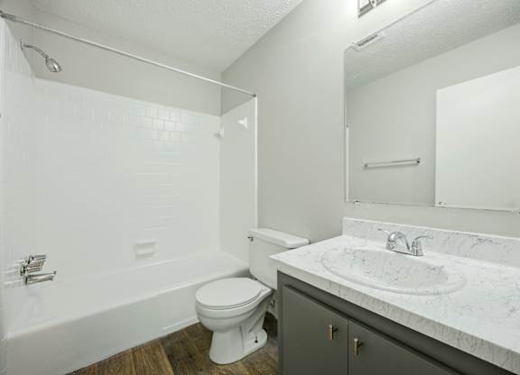 A white bathroom with a toilet, sink, and bathtub.