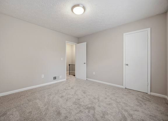 A room with a carpeted floor and a ceiling light.