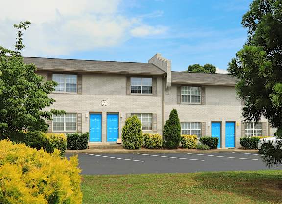 A building with blue doors and windows surrounded by greenery.