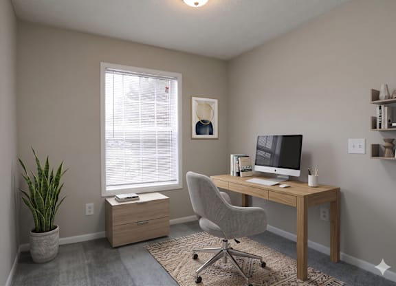 A room with a desk, chair, and a plant.